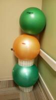 THERABAND LOT OF ASSORTED BALANCE BALLS ON RACK